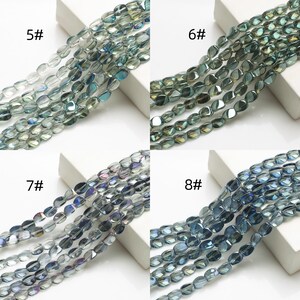 Pode incluir: Close-up de quatro conjuntos de contas de vidro ovais em tons de azul, verde e cinza. Cada conjunto &eacute; rotulado com um n&uacute;mero: 5#, 6#, 7# e 8#. As contas t&ecirc;m um acabamento brilhante, adequadas para fazer joias.