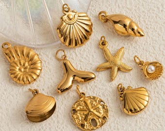 May include: A collection of gold-colored seashell charms, including a starfish, clam, and spiral shell. The charms are designed with intricate details and are displayed on a textured surface. These pendants are ideal for jewelry making.