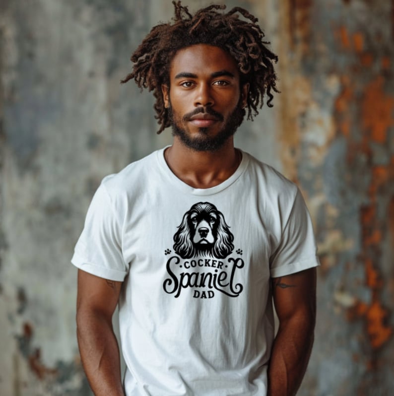 May include: A white t-shirt with a black graphic of a cocker spaniel dog and the text "Cocker Spaniel Dad".