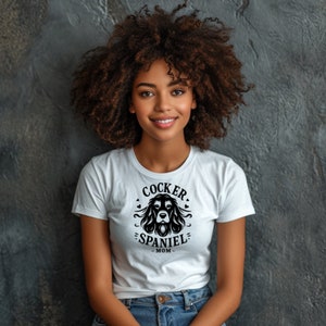 May include: A white t-shirt with a black graphic of a cocker spaniel dog head with the text "Cocker Spaniel Mom".