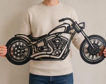 Puede incluir: Una pieza de arte mural de metal negro con forma de motocicleta. El diseño presenta la silueta detallada de una moto tipo crucero con componentes de motor visibles, ruedas de radios, manillar y faro, en un estilo de corte plano.