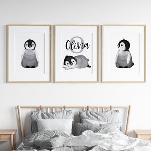 May include: Three black and white framed prints with watercolor illustrations of penguins. The middle print features the name "Olivia" in a circle.