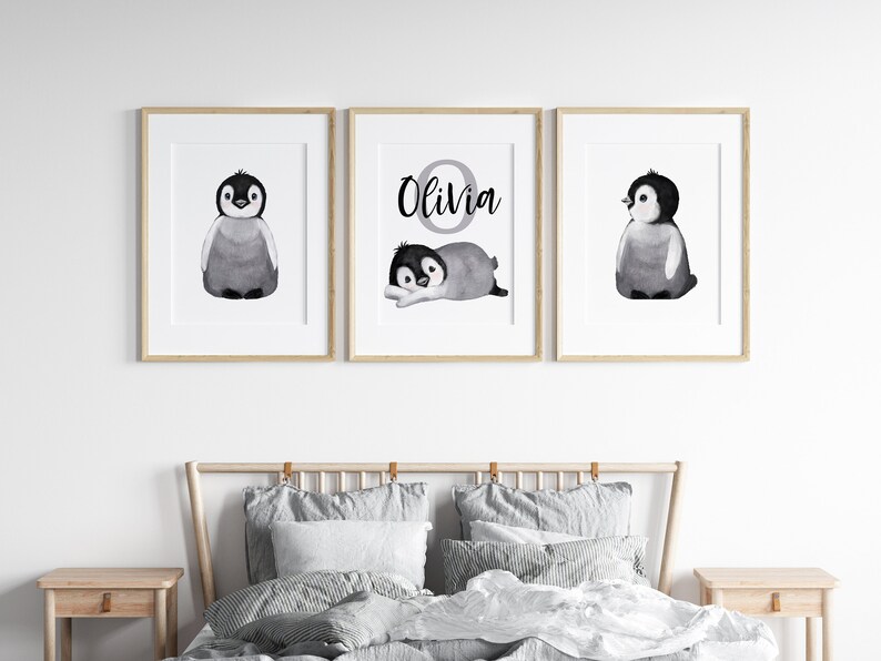 May include: Three black and white framed prints with watercolor illustrations of penguins. The middle print features the name "Olivia" in a circle.