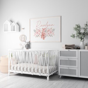 May include: A nursery scene with a white crib, a framed print with the name "Roselynn" and ballet shoes, and a white dresser. The print features pink flowers and ballet shoes. A decorative owl sits on the crib.