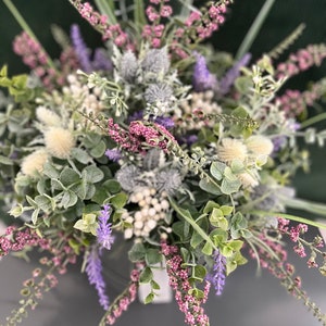 May include: A bouquet of purple and pink flowers with white accents. The flowers are arranged in a vase and the text "LUCE DELL'AMORE" is visible at the bottom of the image.