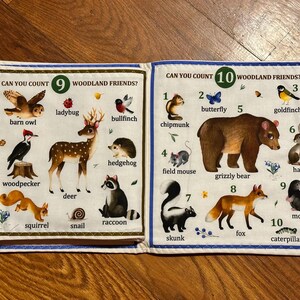 May include: A children's fabric book featuring illustrations of woodland creatures. The pages show numbers and animal names, including "barn owl," "deer," and "grizzly bear." Text reads "Can You Count 9 Woodland Friends?" and "Can You Count 10 Woodland Friends?"
