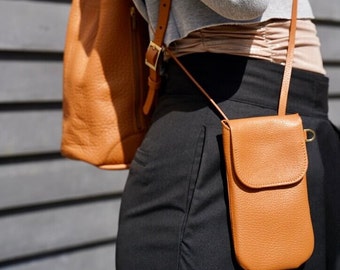 orange leather mobile phone case with money pocket. Slim shoulder bag with magnetic closure. adjustable leather strap. Nice gift idea.