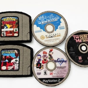 May include: A selection of handmade coasters depicting video game cartridges and discs. The coasters feature designs from "Pokemon Stadium" and "Starfox 64" for the Nintendo 64, and game discs from Nintendo GameCube, PlayStation 2, and "Twisted Metal".
