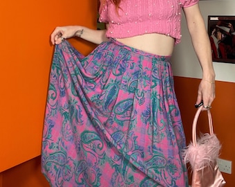 Falda midi plisada rosa pastel con estampado paisley, estilo vintage de los 90, primavera-verano.