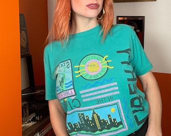 Camiseta verde americana vintage de los años 90 con la Estatua de la Libertad de Nueva York, recuerdo turístico de vacaciones.