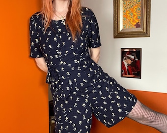 Mono corto azul marino con estampado floral estilo años 90, falda pantalón tipo culotte cruzada, primavera/verano.