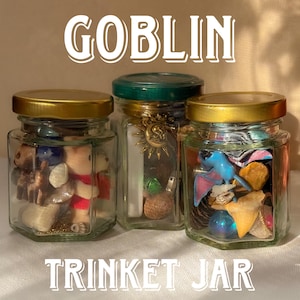 May include: Three glass jars with gold lids filled with trinkets. The jars are labeled "Goblin Trinket Jar".