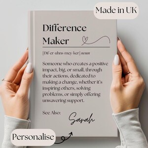 May include: A beige card with the text "Difference Maker" in black font. The card defines the word "Difference Maker" as someone who creates a positive impact, big or small, through their actions. The card also includes the text "See Also:" and a handwritten signature that says "Sarah".
