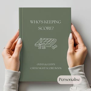 Pode incluir: Um livro de pontuação de noite de xadrez verde sálvia segurado por mãos. A capa apresenta o texto "WHO'S KEEPING SCORE?" acima de uma ilustração de tabuleiro de xadrez. Abaixo da ilustração está o texto "OLIVIA & LIAM'S CHESS NIGHT SCORE BOOK". A palavra "Personalise" está em uma caixa branca.