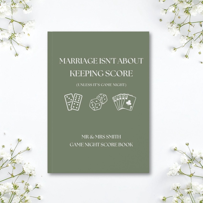 May include: A sage green score book with white text that reads MARRIAGE ISN'T ABOUT KEEPING SCORE (UNLESS IT'S GAME NIGHT) followed by MR & MRS SMITH GAME NIGHT SCORE BOOK. The cover features white line art of dominoes, dice, and playing cards.