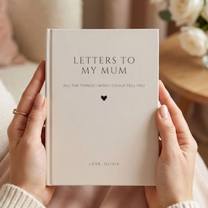 Op de afbeelding: Een crèmekleurig hardcover boek met zwarte tekst die LETTERS TO MY MUM, ALL THE THINGS I WISH I COULD TELL YOU en LOVE, OLIVIA leest. Een klein zwart hartsymbool is gecentreerd tussen de ondertitel en de naam onderaan de voorzijde.