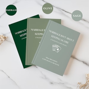 May include: Three hardcover score books in emerald, olive, and sage green. Each cover features the white text "MARRIAGE ISN'T ABOUT KEEPING SCORE (UNLESS IT'S GAME NIGHT)", a graphic of playing cards, and "MR & MRS SMITHS GAME NIGHT SCORE BOOK".