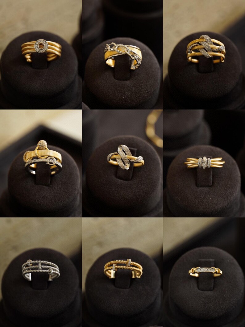 Pu&ograve; includere: Nove anelli in oro e argento con accenti di diamanti esposti su cuscini di velluto nero. Gli anelli presentano vari design, tra cui un cerchio, un nodo e una linea retta.