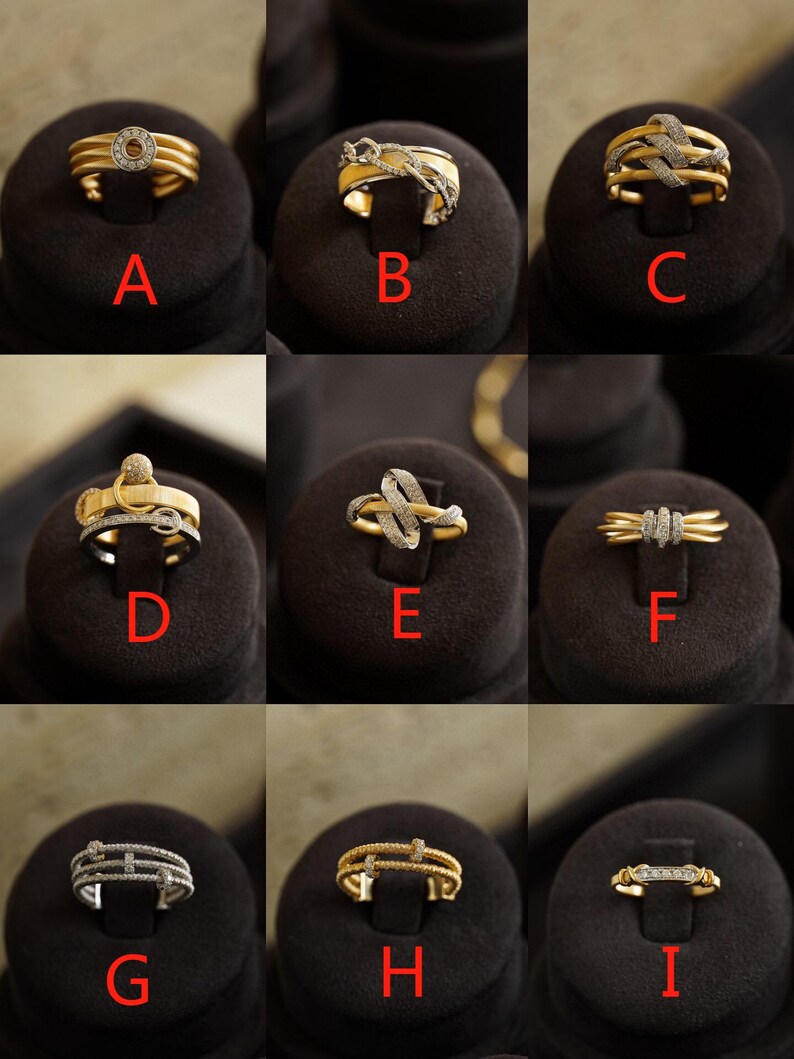 Pu&ograve; includere: Nove anelli in oro e argento con dettagli in diamanti, esposti su supporti in velluto nero. Gli anelli presentano diversi design, tra cui una fascia semplice con un solo diamante, una fascia intrecciata con diamanti e una fascia con pi&ugrave; file di diamanti.