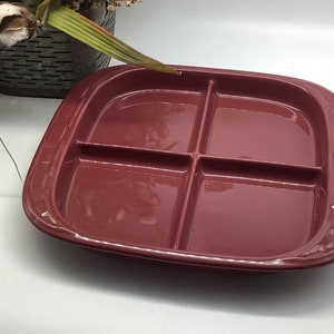 Puede incluir: Un plato para servir de cerámica de color burdeos con cuatro secciones divididas. El plato tiene un borde ligeramente elevado y un acabado liso y brillante.