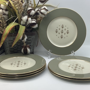 May include: Set of four green and gold rimmed dinner plates with a floral pattern.