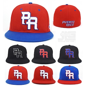 May include: A collection of baseball caps in various colors, including red, black, and blue. Each cap features the letters "PR" in a contrasting color, with "Puerto Rico" embroidered on the back of some. The caps have a flat brim.