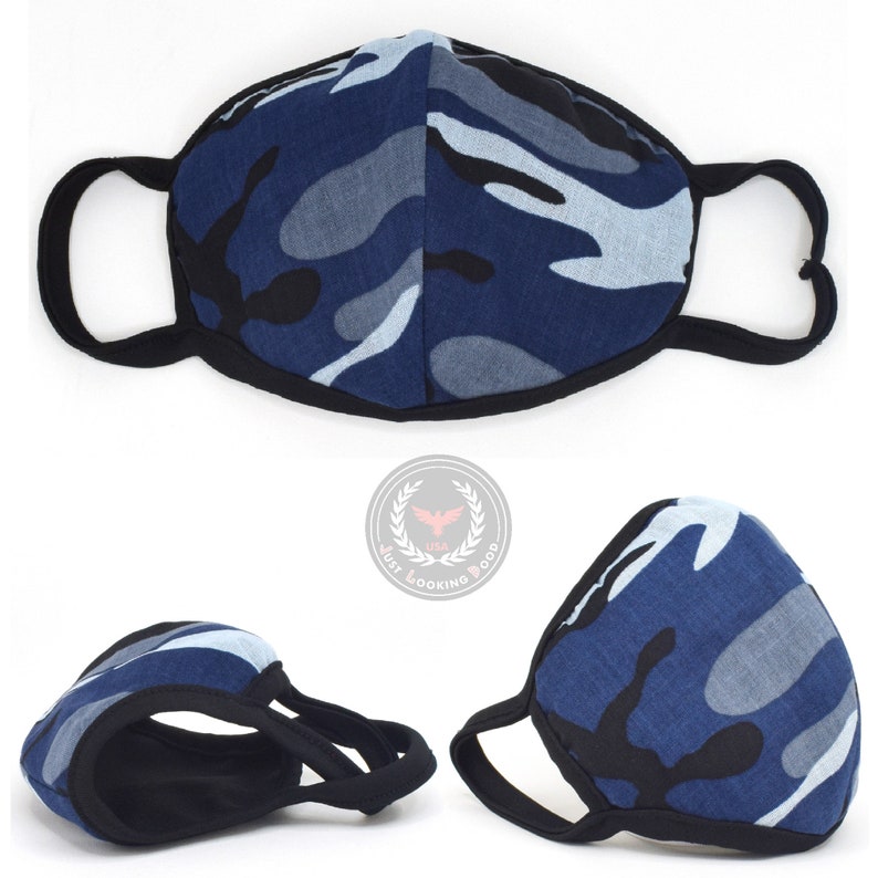 May include: A blue, black, and gray camouflage face mask with black elastic ear loops. The mask is made of a soft, breathable fabric.
