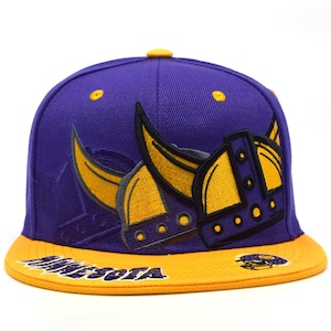 May include: A purple and gold baseball cap with a Viking helmet emblem. The cap has a flat brim with the word "MINNESOTA" embroidered in white. The crown is purple with gold detailing.