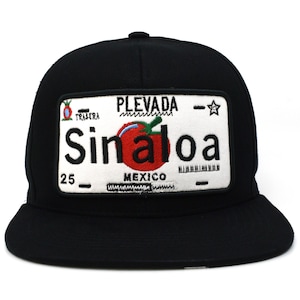 May include: A black baseball cap featuring a rectangular embroidered patch on the front. The patch resembles a license plate with a white background, the text "PLEVADA", "Sinaloa", "MEXICO", and "25", and a central red tomato graphic.