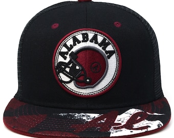 Può includere: Cappellino da baseball nero e rosso con un logo ricamato bianco e rosso che dice "ALABAMA" con un casco da football all'interno del cerchio. Il visore del cappello ha un motivo mimetico rosso e bianco.