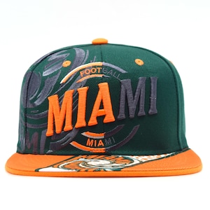 May include: A dark green baseball cap with an orange brim and an orange button on top. The front features the word MIAMI embroidered in orange and dark gray, with the word FOOTBALL above it and a swirling graphic pattern in dark gray and white.