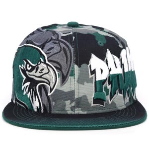 Könnte beinhalten: Eine Baseballkappe mit Camouflage-Muster und flachem Schirm. Sie zeigt eine grüne und graue Adlergrafik und das Wort "PAW" in Weiß und Grün. Oben befindet sich ein grüner Knopf. Ein modisches Accessoire.