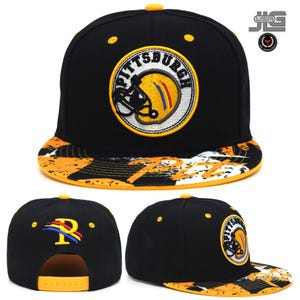 May include: Black baseball cap featuring a Pittsburgh Steelers logo in yellow and white. The brim has a yellow, white, and black pattern. The cap has a yellow button and an adjustable yellow snap closure at the back.