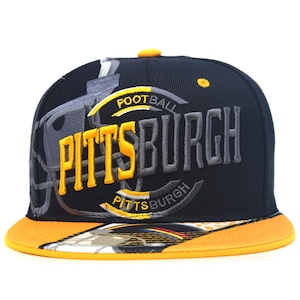 May include: A black baseball cap featuring yellow and grey embroidered text that reads PITTSBURGH FOOTBALL. The design includes a grey football helmet graphic on the side and a yellow brim with a partial graphic print on the underside.