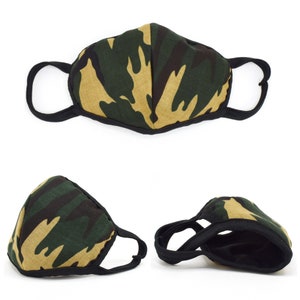 May include: A green and brown camouflage face mask with black elastic ear loops. The mask is made of fabric and has a contoured shape.