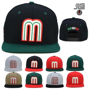 May include: A set of ten baseball caps in various colors, each featuring a stylized "M" logo with red, white, and green stripes. The caps are made of a black, green, red, gray, or beige fabric. The caps have a curved brim and a snap closure.