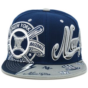 May include: A navy blue baseball cap with the words "New York" in white and grey. The cap features a baseball graphic with the letters "NY" and the word "Baseball". The brim is grey with repeating "NY" and baseball graphics.