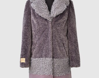 May include: A long-sleeved, purple faux fur coat with a gray collar and a pink trim. The coat has two pockets and a button closure.