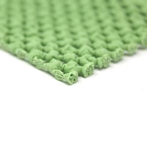 May include: Close-up of a green, textured, rubber mat with a grid pattern. The mat is made of small, interconnected squares.