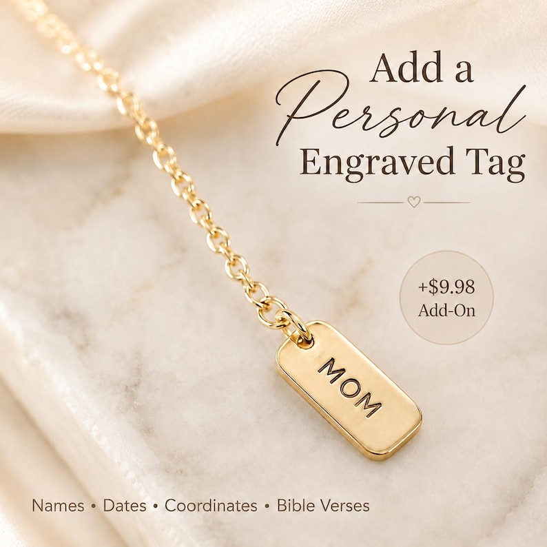 May include: A gold-toned metal chain featuring a small, rectangular engraved tag with the word MOM stamped in black capital letters. The text Add a Personal Engraved Tag, +$9.98 Add-On, and Names, Dates, Coordinates, Bible Verses are visible.