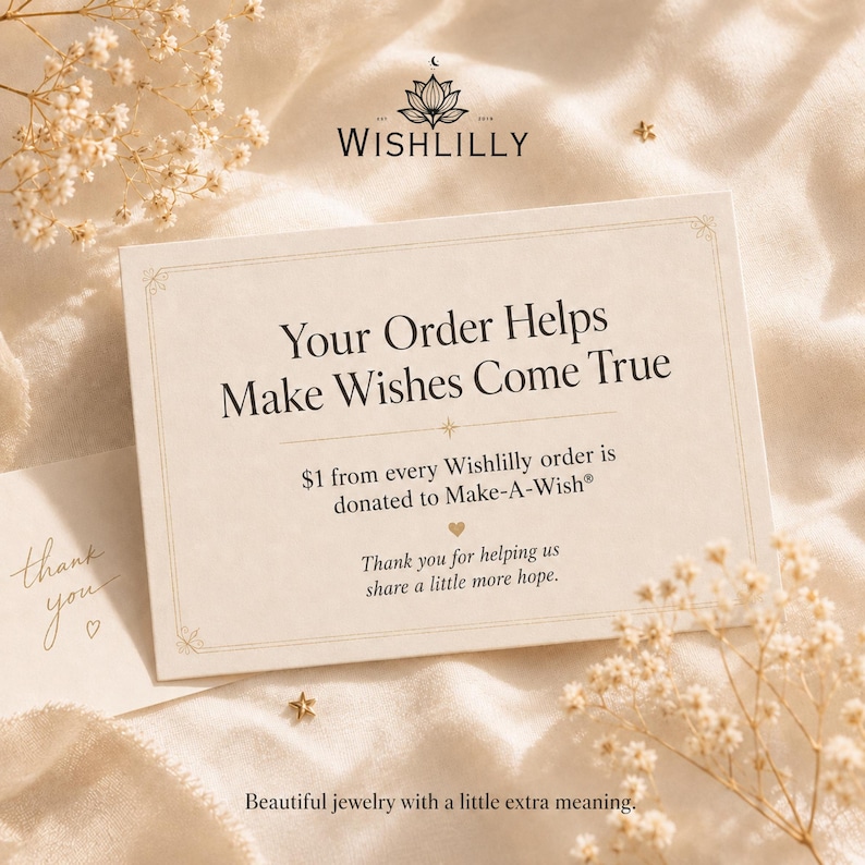 May include: A rectangular cream-colored card with the text "Your Order Helps Make Wishes Come True" and "$1 from every Wishlilly order is donated to Make-A-Wish". The card features a logo with a lotus flower and the brand name "WISHLILLY".
