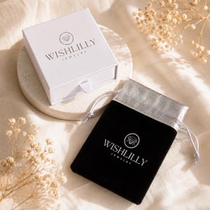 May include: A white square jewellery box with a pull-out drawer and the black text WISHLILLY JEWELLERY with a diamond icon, alongside a black velvet drawstring pouch featuring a silver top and the white text WISHLILLY JEWELLERY with a diamond icon.