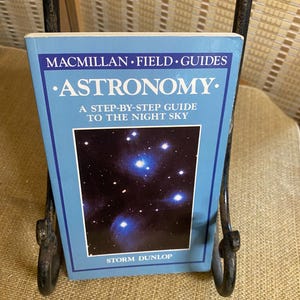 May include: A blue book titled "Astronomy: A Step-by-Step Guide to the Night Sky" by Storm Dunlop. The cover features a photograph of a dark night sky with stars.