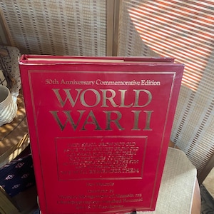 May include: A red hardcover book titled "World War II" with gold lettering. The book is a 50th Anniversary Commemorative Edition and features a quote about remembering those who served. The book is by Time-Life Books and is part of the "The World War II" series.