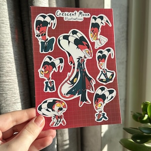 Op de afbeelding: Een vel stickers met een cartoonfiguur met rode, zwarte en witte strepen. Het figuur is in verschillende poses en uitdrukkingen. De stickers zijn op een rode achtergrond met een rasterpatroon. De tekst "Crescent Moon Illustrations" staat bovenaan het vel.