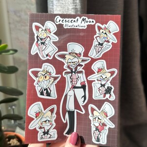 Pu&ograve; includere: Un foglio di adesivi con un personaggio dei cartoni animati con una corona, un abito bianco e un papillon rosso. Il personaggio &egrave; mostrato in diverse pose ed espressioni. Gli adesivi sono su uno sfondo a scacchi rosso e bianco. Il testo "Crescent Moon Illustrations" &egrave; in cima al foglio.