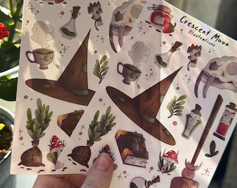 Puede incluir: Dos hojas de pegatinas con ilustraciones de artículos de bruja, que incluyen un sombrero de bruja, un caldero, una escoba, un libro, una botella de poción, una calavera y hongos. Las pegatinas son de Crescent Moon Illustrations.