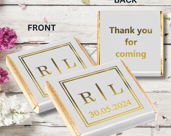 May include: Two white chocolate bars with gold foil wrappers. The front of the bar has a gold square with the initials "R|L" and the date "30.05.2024". The back of the bar has the text "Thank you for coming" in gold lettering.