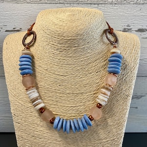 Ashanti Bead Necklace with Fair Trade Beads. Blue and White Disc Ashanti Beads. Recycled Glass Pink Beads. Shell Heishi Beads. Button clasp.