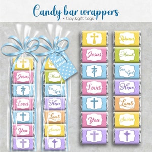 Op de afbeelding: Snoepreepverpakkingen met religieuze thema's, waaronder de woorden "Jezus", "Liefde" en "Hoop". De verpakkingen zijn in verschillende pastelkleuren en hebben kruisontwerpen. Sommige zijn verpakt in doorzichtige cellofaan zakken met blauw lint en een cadeaulabel met "Vrolijk Pasen".